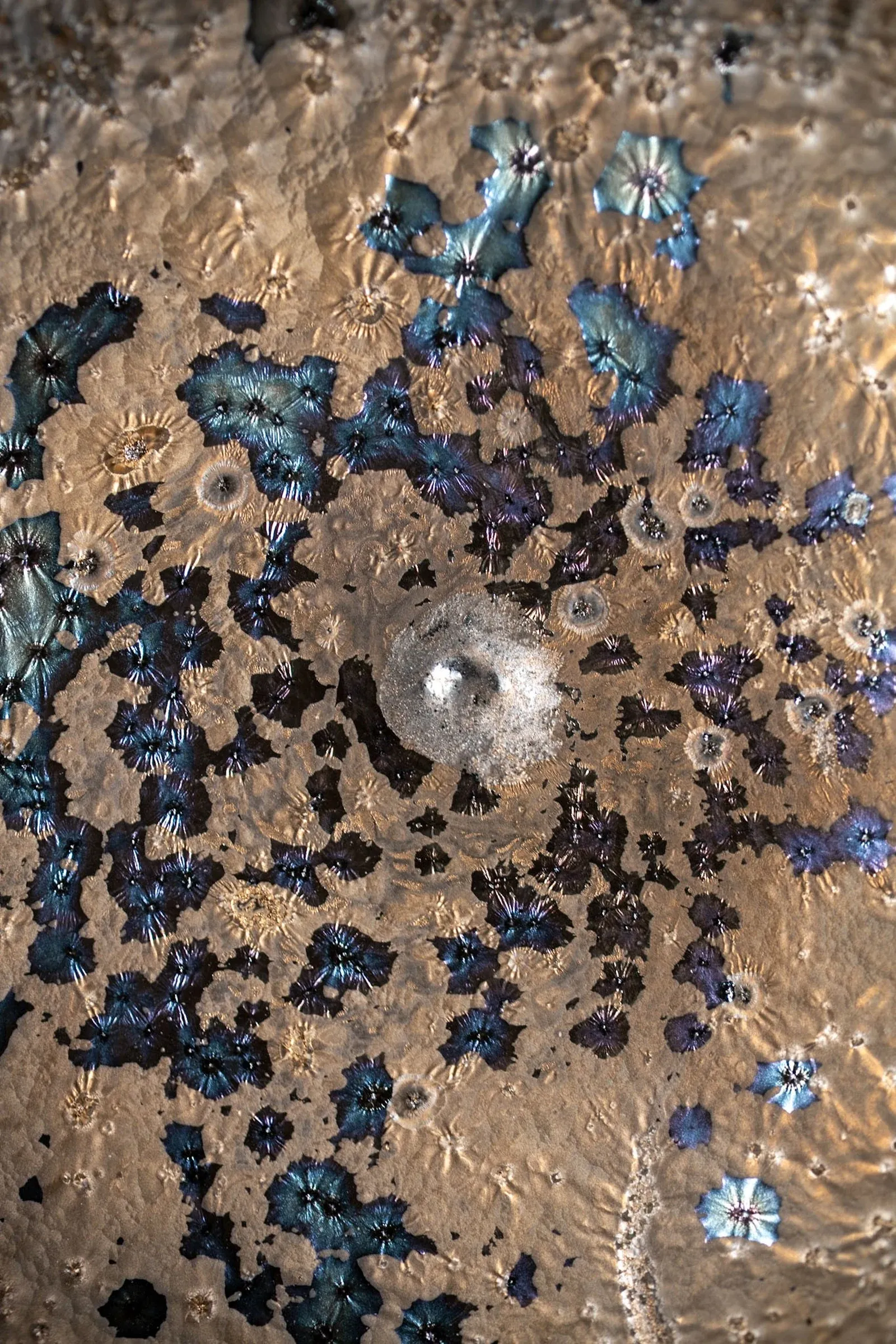 Glaze pooled across a speckled ceramic surface